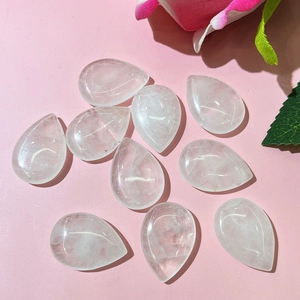 Pierres de cristal blanc polies en forme de goutte avec fissures naturelles sur fond rose