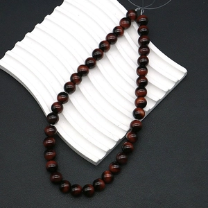 Macro detail of red tiger eye stone beads showing natural stripes and cat eye effect texture
