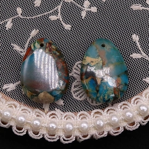Macro view of teardrop natural stone pendants with unique colorful textures for DIY jewelry