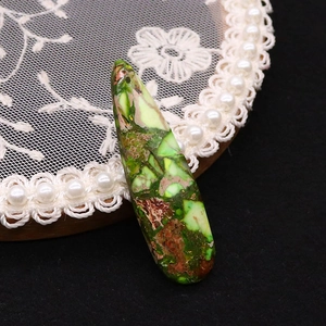 Dettaglio macro del ciondolo in pietra imperatore a goccia con trama marmorizzata verde