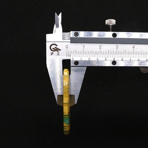Messung der 6mm Dicke des ovalen Naturstein-Anhängers mit digitalem Messschieber im Detail