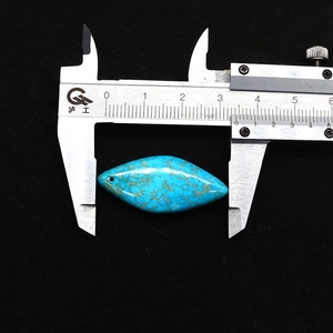 Détail montrant la mesure d'un pendentif turquoise de 3,5 cm avec texture naturelle