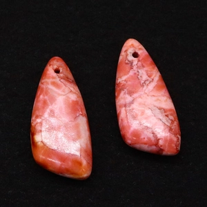Macro detail van gepolijste druppelvormige keizersteen hangers met roze marmertextuur