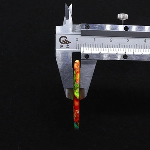 Detail shot measuring 5-6mm thickness of teardrop imperial stone pendant with digital caliper