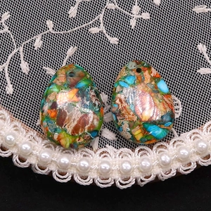 Detailed view of teardrop stones with colorful patchwork textures for DIY necklaces