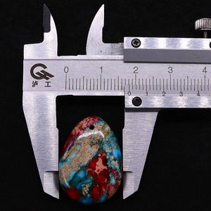 Macro view showing the 18mm width measurement of a teardrop synthetic stone pendant