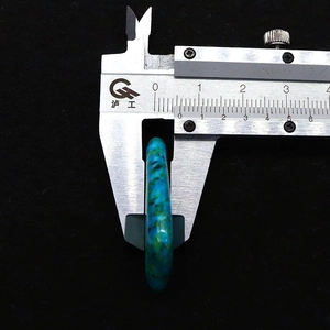 Gedetailleerd zicht van een 8,8 mm brede driehoekige stenen hanger in blauw-groen