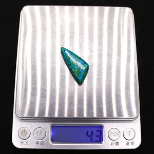 Macro-opname van 4,3g turquoise driehoekige hanger op digitale weegschaal voor gewicht