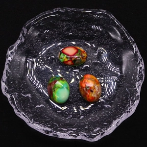 Tres cuentas ovaladas de piedra imperial con texturas moteadas de colores en una bandeja