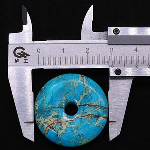 Detailed measurement of turquoise donut pendant showing approximately 26mm diameter size