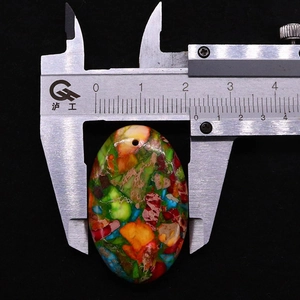 Misurazione della larghezza di 24 mm di un ciondolo a goccia in pietra colorata con un calibro