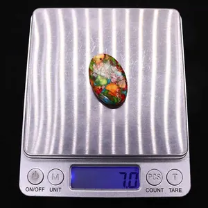Dettaglio del ciondolo ovale in pietra colorata con peso di 7,0g su bilancia digitale