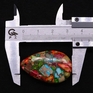 Dettaglio di un ciondolo in pietra imperiale multicolore misurato con un calibro a corsoio