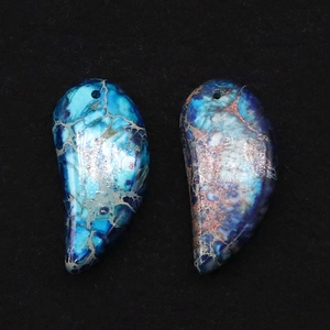 Close-up of crescent imperial jasper pendants with blue marble texture and pre-drilled holes