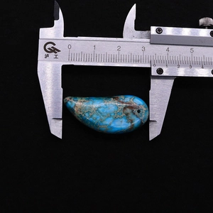 Dettaglio di un ciondolo turchese a forma di foglia da 34 mm con trame naturali marroni