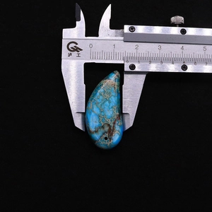 Dettaglio macro del ciondolo in pietra imperiale azzurra misurato con un calibro