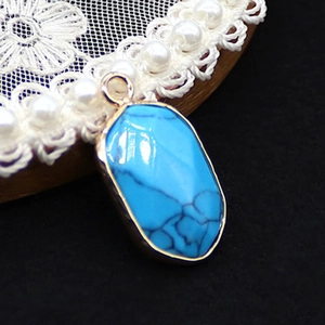 Macro-opname van de blauwe stenen hanger met zwarte aders en een goudkleurige rand