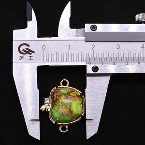 Détail d'un pendentif pomme en pierre naturelle de 18 mm mesuré avec un pied à coulisse