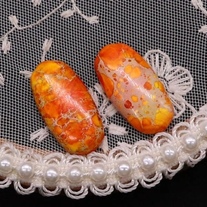 Macro-detail van ovale oranje Keizerlijke Jaspis edelsteenkralen met natuurlijke texturen