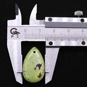 Detailansicht eines tropfenförmigen Natursteinanhängers mit 24mm Breite am Messschieber