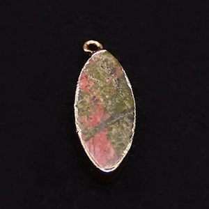Macro shot of marquise unakite pendant with golden metal edges and natural green pink patterns
