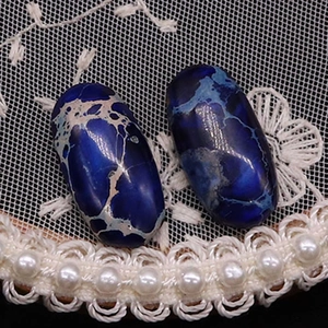 Macro-weergave van twee ovale blauwe keizerlijke jaspis cabochons voor DIY-sieraden