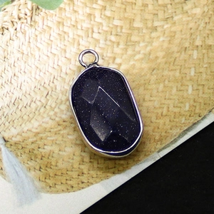 Macro detail of blue sandstone pendant with faceted edges and silver electroplated rim