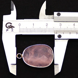 Macro view measuring the 2.5cm width of the faceted pink crystal pendant with gold plating