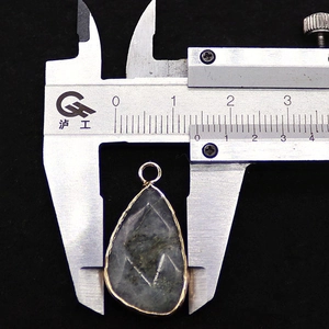 Detailed size measurement of a gold plated faceted triangular opal stone pendant with a caliper