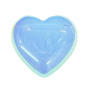 Close-up of heart-shaped opalite stone with smooth polished finish and blue glow