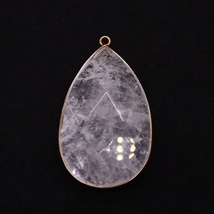 Detailed macro view of teardrop natural stone pendant with gold-plated metal edging