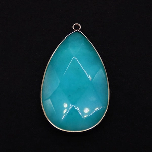 Macro detail of faceted teardrop gemstone pendant with elegant gold plated edge