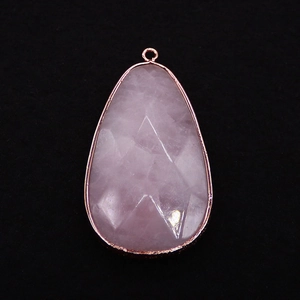 Macro view of a faceted pear-shaped rose quartz pendant with rose gold plated edging