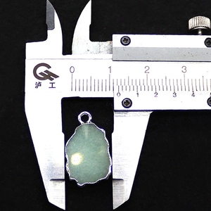 Makroaufnahme von 2,0 cm grünem Aventurin-Anhänger mit versilbertem Rand auf Samt