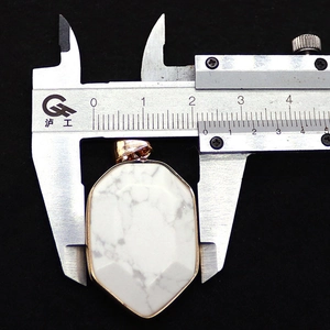 Macro shot showing 2.6cm width of shield-cut howlite stone pendant with rose gold frame