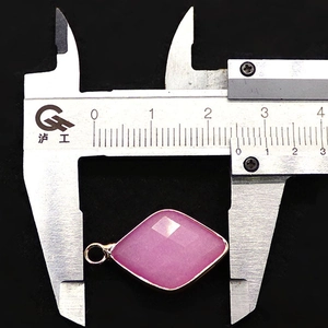Macro shot of pink natural faceted stone pendant measured with a caliper for size accuracy