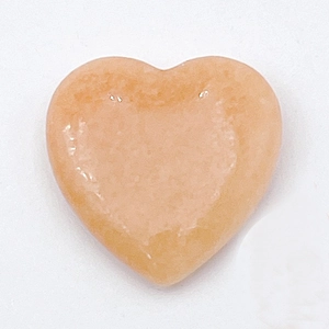 Close-up of polished peach heart-shaped natural stone bead for DIY jewelry making