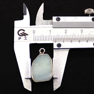 Detail view of irregular Tiger Eye stone pendant with gold plating measured by caliper