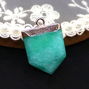 Detailed macro view of sword-shaped green natural stone pendant with gold metallic cap