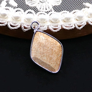 Macro shot of rhombus natural stone pendant with silver metal plating and textured pattern