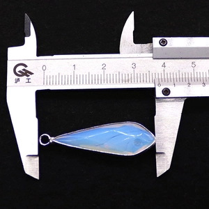 Detail showing teardrop blue natural stone pendant measured with a caliper for size accuracy
