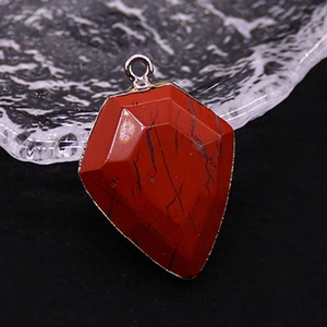 Macro detail of shield-cut red jasper stone pendant with natural black vein textures