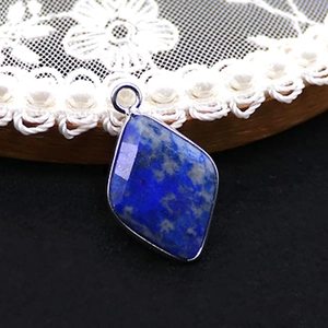 Macro detail of a diamond-shaped blue lapis lazuli pendant with silver metal plating