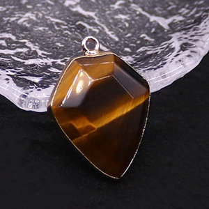 Macro shot of tiger eye stone pendant showing golden luster and metal border
