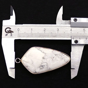 Détail d'un pendentif en pierre naturelle en forme de bouclier de 42mm avec bord doré