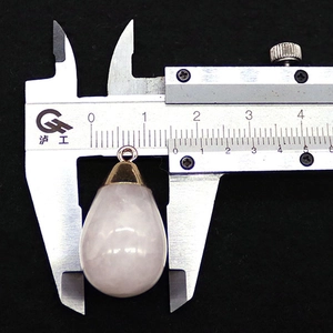 Macro-opname van een 15mm rozenkwarts druppelhanger met gouden metalen oogje
