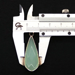 Macro-opname die de breedte van 13mm meet van een gefacetteerde groene agaat hanger