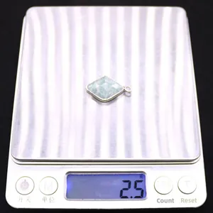 Makroansicht von Larimar-Steinanhänger auf Waage zeigt ein Gewicht von 2,5 Gramm