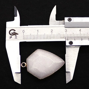 Macro shot of a pentagon white natural stone pendant with gold bezel and measurement