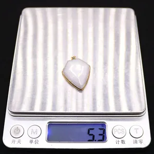Macro shot showing 5.3g weight of shield-shaped turquoise pendant on digital scale